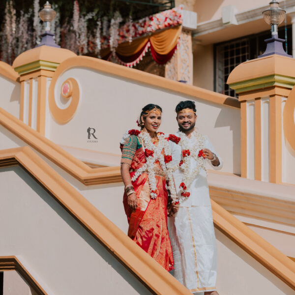Recently married couple posing for a photoshoot at the hall entrance