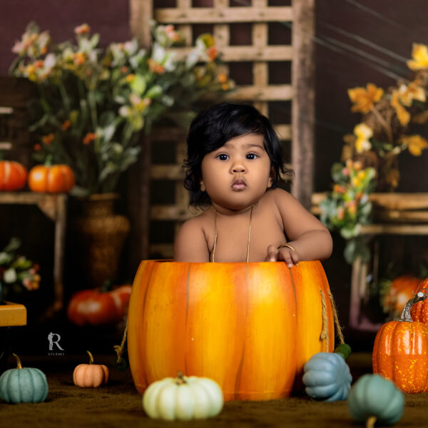Chubby little baby in pumpkin-themed baby photoshoot